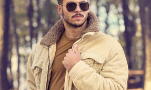 Stylish man with sunglasses posing in autumn park